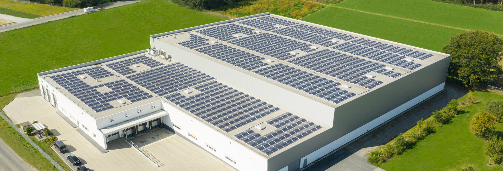 Das Bild zeigt eine der Fulfillmenthallen von RHIEM, deren Dach mit Solarzellen zur Stromproduktion bestückt ist.