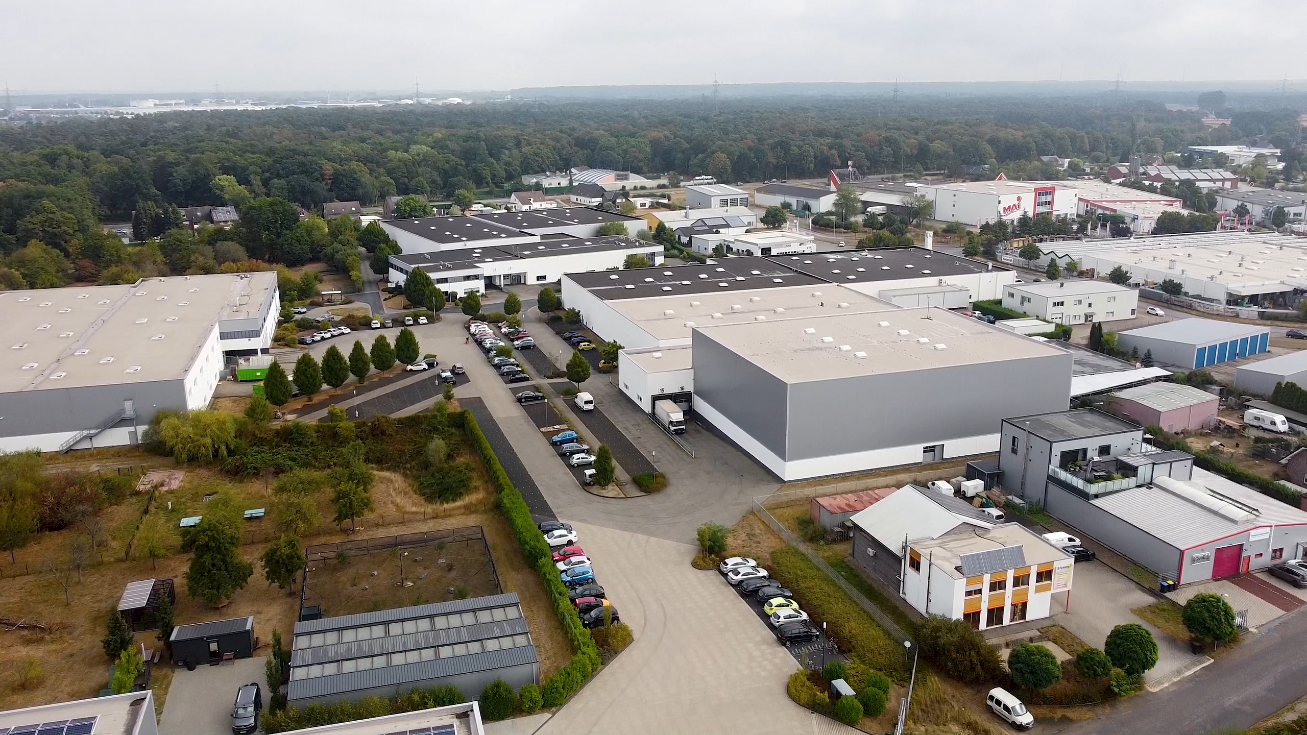 The picture shows the RHIEM Campus in Voerde. You can see the warehouses and production halls as well as the central parking lot in between.