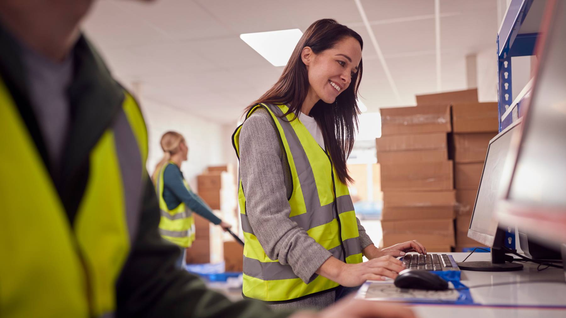 Eine Fulfillment Mitarbeiterin überwacht und bucht am Computer die Bestandsbewegungen der Artikel im Fulfillment Lager