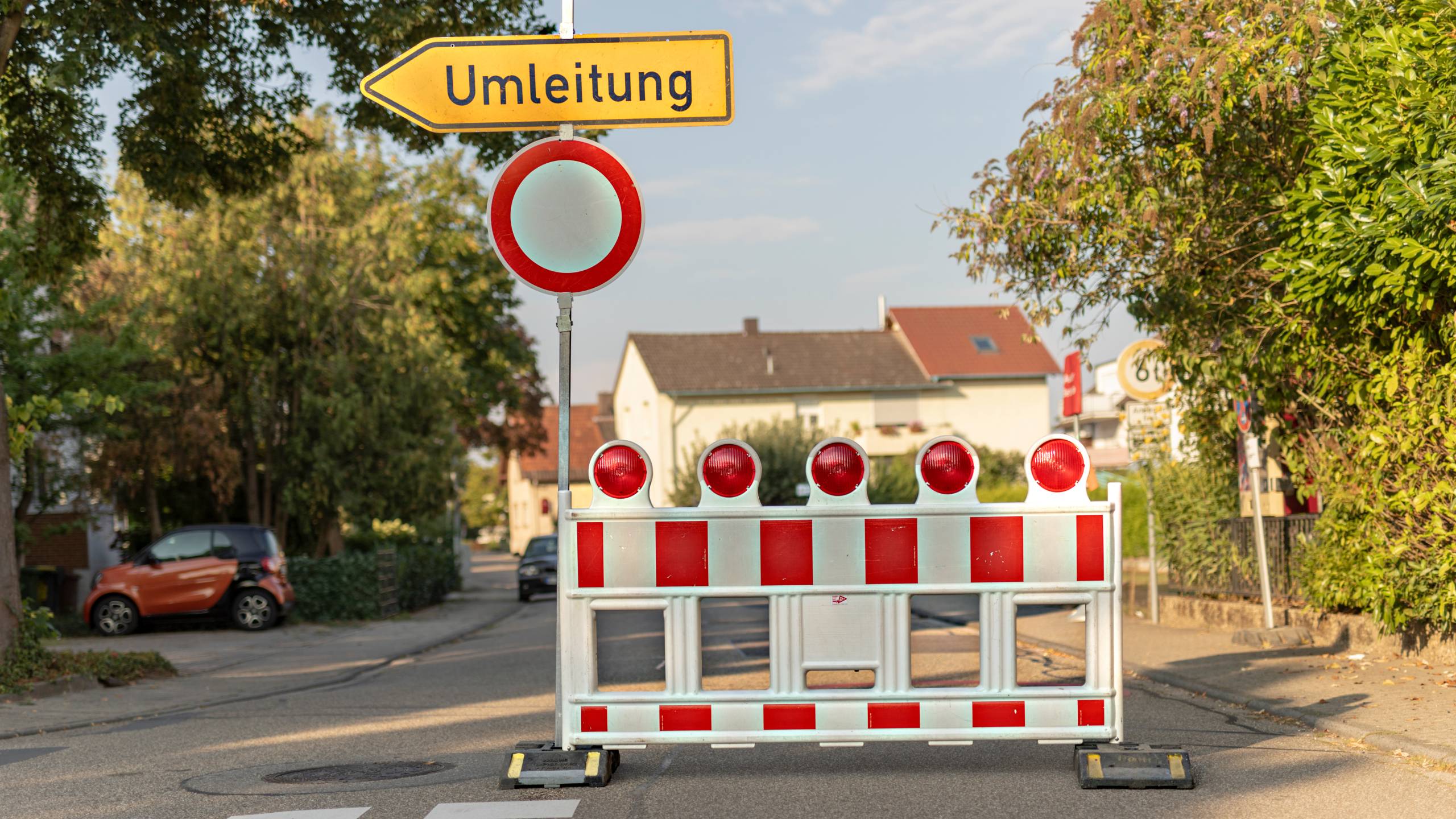 On a road in a quiet residential area there is a sign announcing a detour